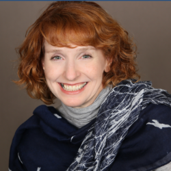 Jen French headshot 900x1080_v2 Smiling woman with short auburn hair wearing a navy blue scarf and gray turtleneck against a neutral background.